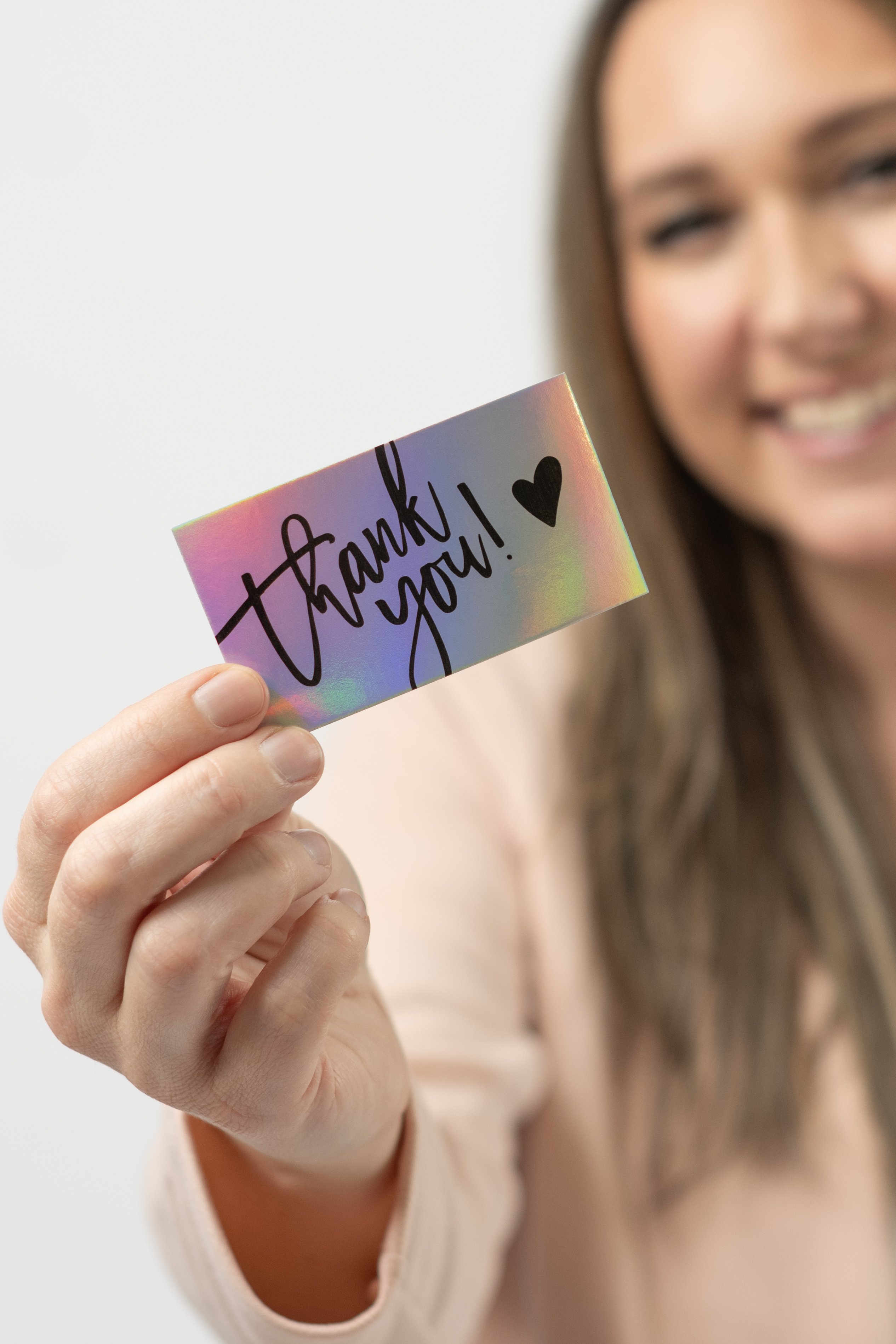 Sarah Jones, FNP-BC, owner of Glow Medical Group, holding a thank-you card
